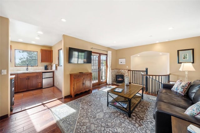 living room featuring sink, light wood-type flooring, and french doors