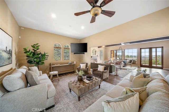 living room with light hardwood / wood-style flooring, a wealth of natural light, lofted ceiling, and ceiling fan