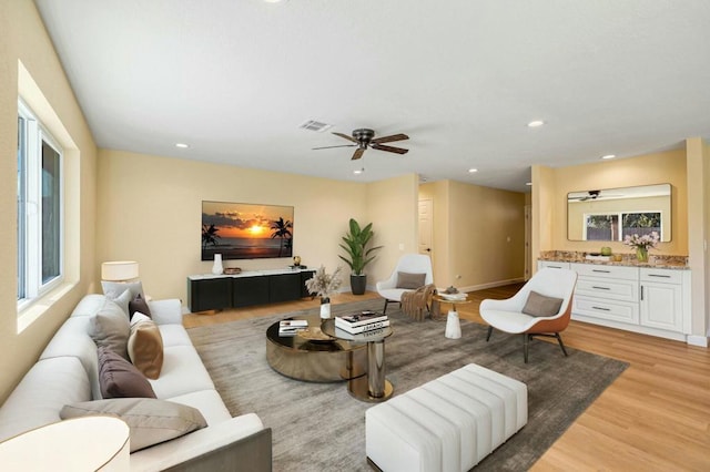 living room featuring light wood-type flooring and ceiling fan