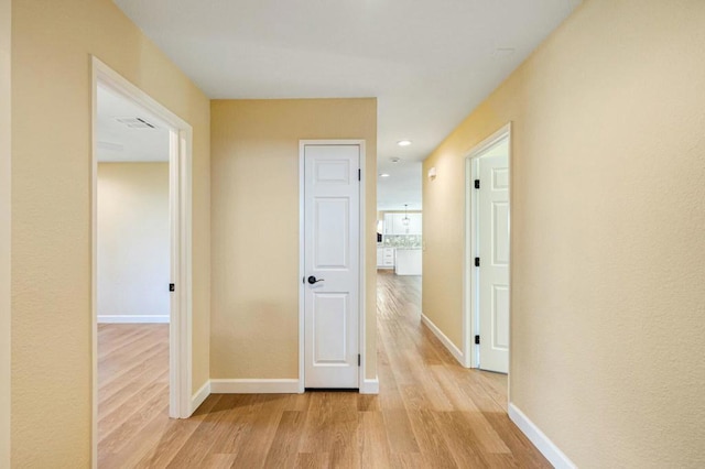 hallway with light hardwood / wood-style floors