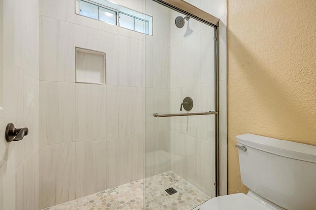 bathroom with toilet and an enclosed shower