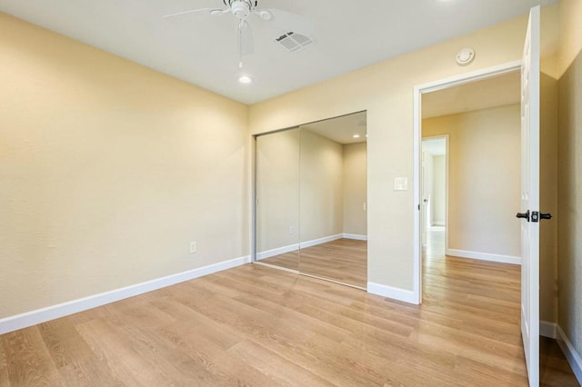 unfurnished bedroom with a closet, light hardwood / wood-style floors, and ceiling fan