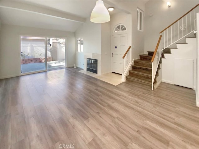 8354 Gabriel Dr Unit B, Rancho Cucamonga, CA 91730 - unfurnished living room featuring stairs, light wood finished floors, baseboards, beam ceiling, and high vaulted ceiling