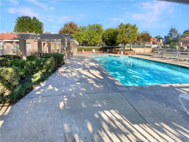 community pool featuring a pergola, fence, and a patio area