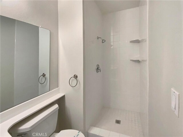 full bath featuring toilet and tiled shower