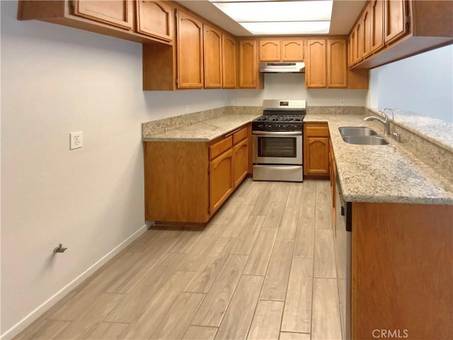 8354 Gabriel Dr Unit B, Rancho Cucamonga, CA 91730 - kitchen with stainless steel gas range oven, under cabinet range hood, a sink, brown cabinets, and light wood-type flooring