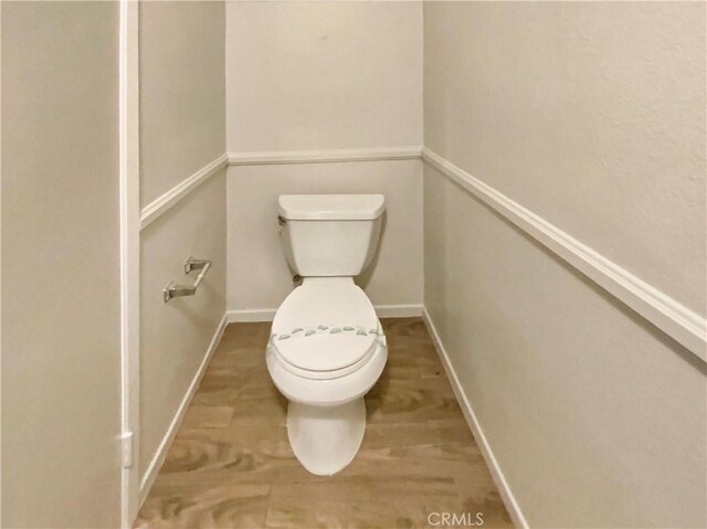 bathroom featuring baseboards and toilet