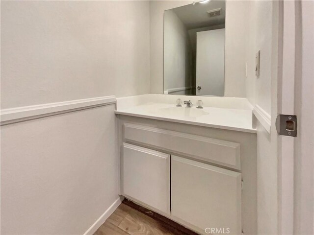 bathroom with baseboards, visible vents, and vanity