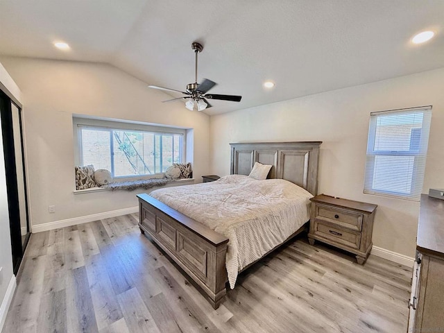 bedroom with ceiling fan, light hardwood / wood-style floors, and vaulted ceiling