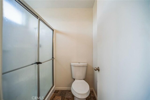 bathroom with an enclosed shower and toilet