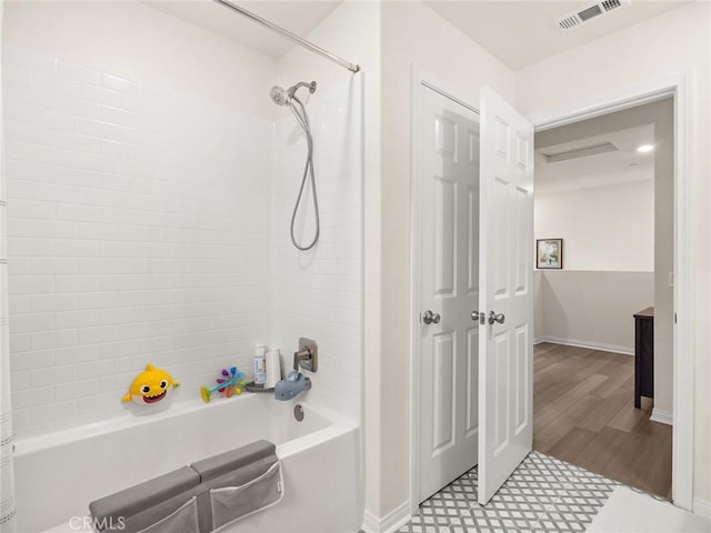 bathroom featuring hardwood / wood-style flooring and shower / bathtub combination with curtain