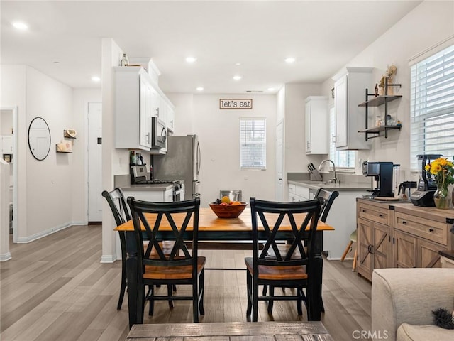 dining room featuring sink and light hardwood / wood-style flooring