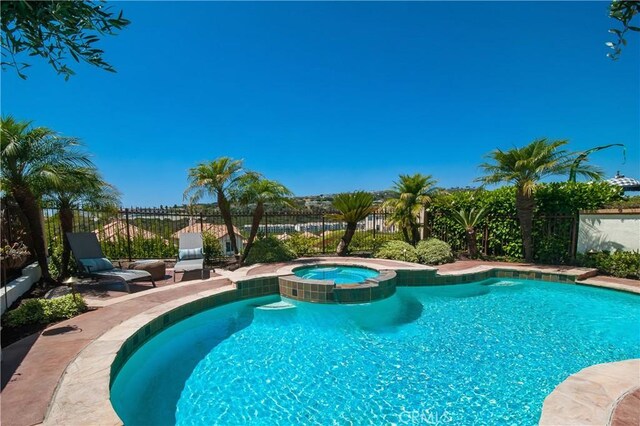 view of swimming pool with an in ground hot tub