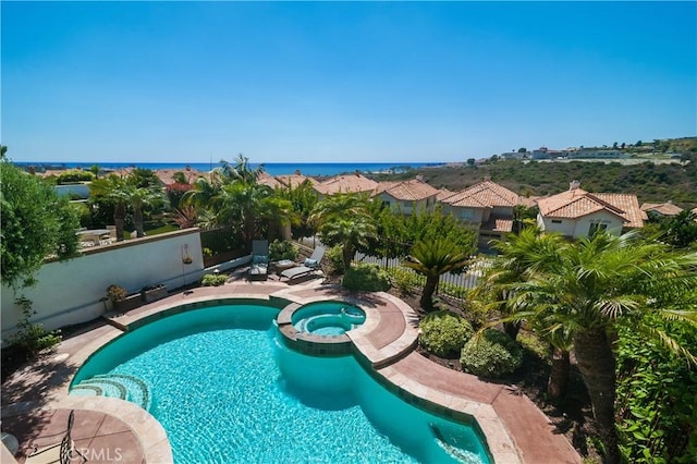 view of swimming pool with a water view and an in ground hot tub