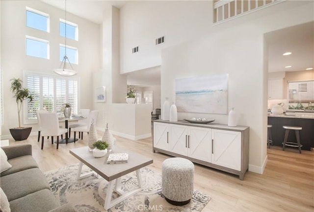 living room featuring a high ceiling and light wood-type flooring