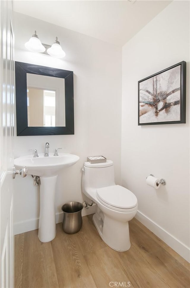 bathroom with hardwood / wood-style flooring, sink, and toilet