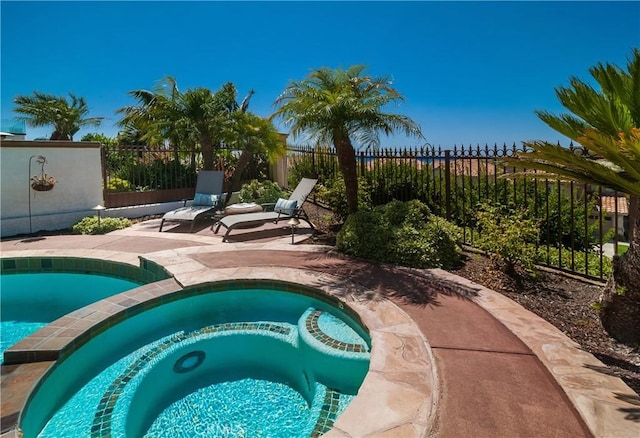 view of swimming pool featuring an in ground hot tub and a patio