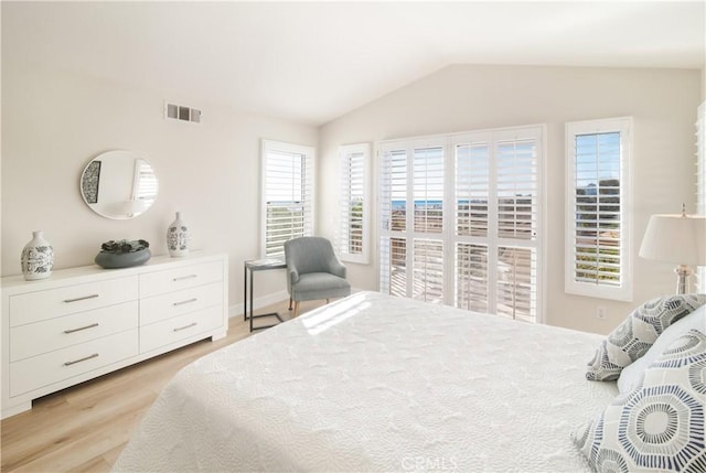 bedroom with lofted ceiling and light hardwood / wood-style floors