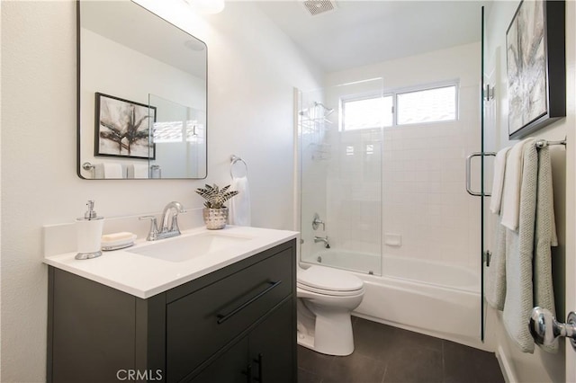 full bathroom featuring tile patterned flooring, vanity, shower / bath combination with glass door, and toilet