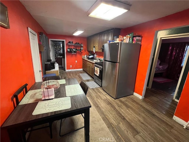 kitchen with dark hardwood / wood-style flooring and appliances with stainless steel finishes