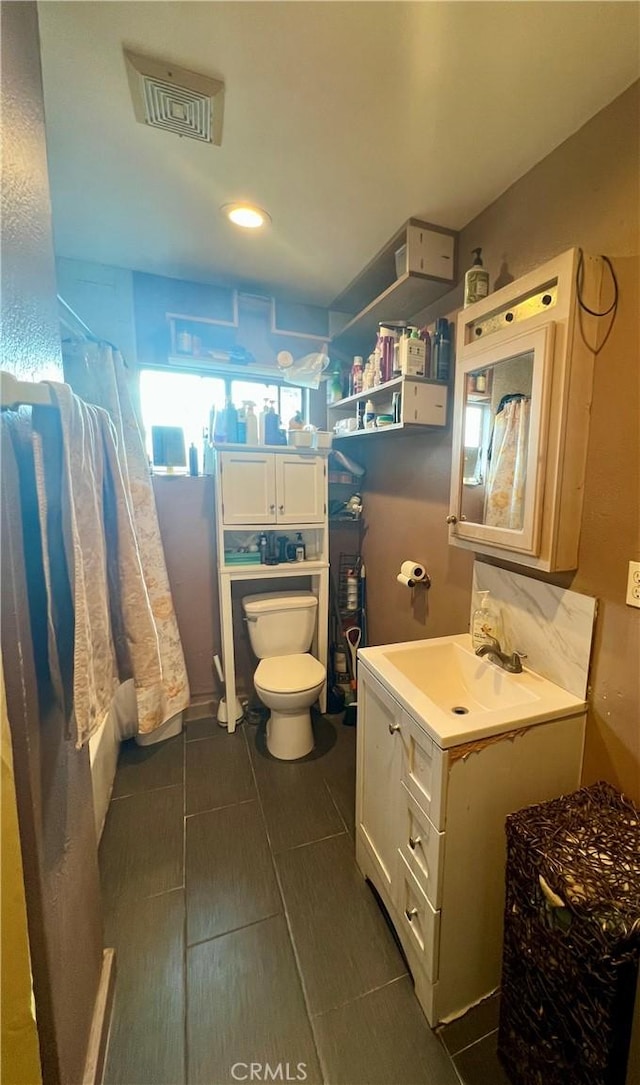 bathroom featuring tile patterned flooring, vanity, and toilet