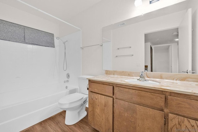 full bathroom featuring toilet, hardwood / wood-style floors, vanity, and bathing tub / shower combination