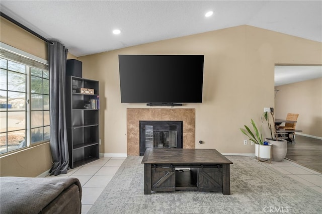 living room with lofted ceiling, light tile patterned flooring, and a textured ceiling