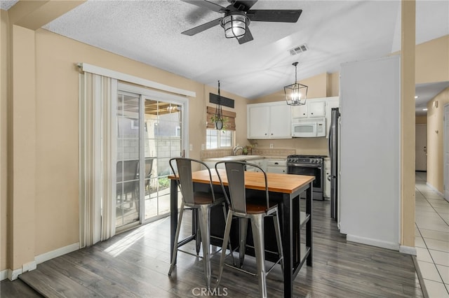 dining room featuring vaulted ceiling, ceiling fan with notable chandelier, dark hardwood / wood-style floors, and sink