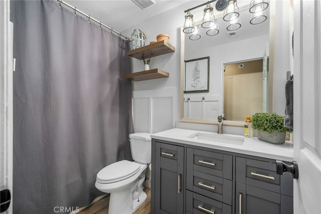 bathroom with hardwood / wood-style flooring, toilet, and vanity