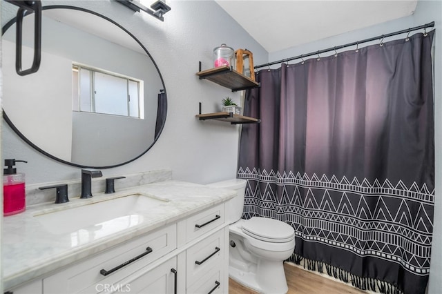 bathroom featuring hardwood / wood-style flooring, toilet, vanity, and walk in shower