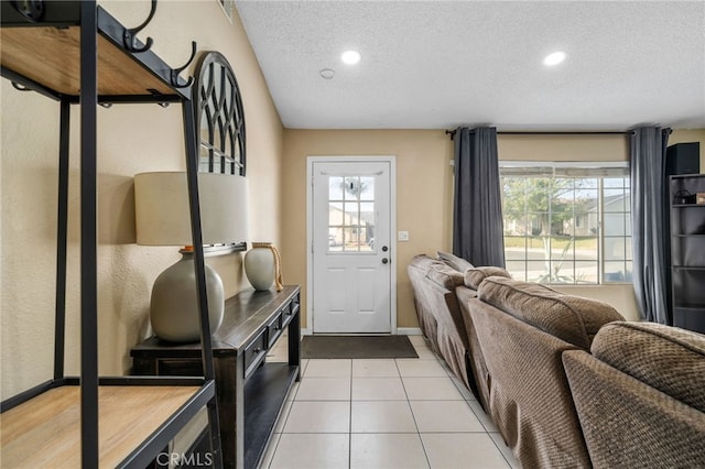 doorway to outside with light tile patterned floors and a textured ceiling