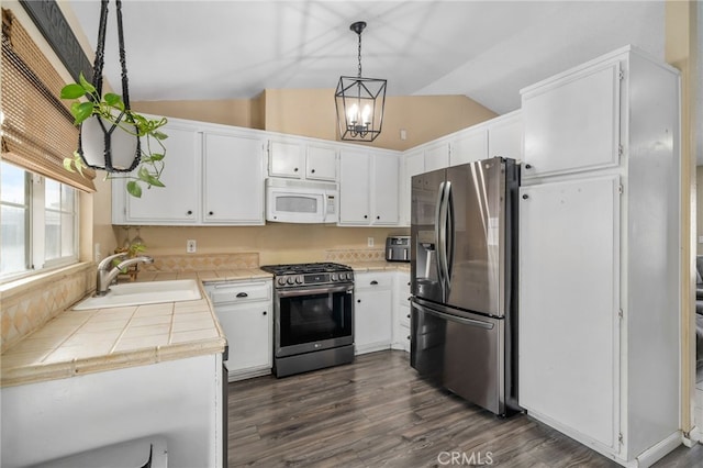 kitchen featuring decorative light fixtures, white cabinets, sink, and stainless steel appliances