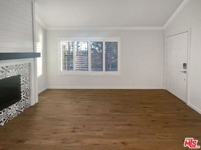 unfurnished living room with a tile fireplace, ornamental molding, and dark wood-type flooring