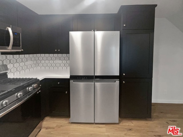 kitchen featuring light wood-type flooring, stainless steel appliances, and tasteful backsplash