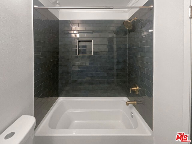 bathroom with toilet and tiled shower / bath