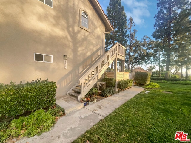 view of property exterior featuring a lawn and central AC unit