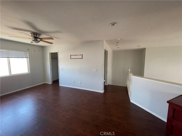 unfurnished room featuring ceiling fan and dark wood-type flooring