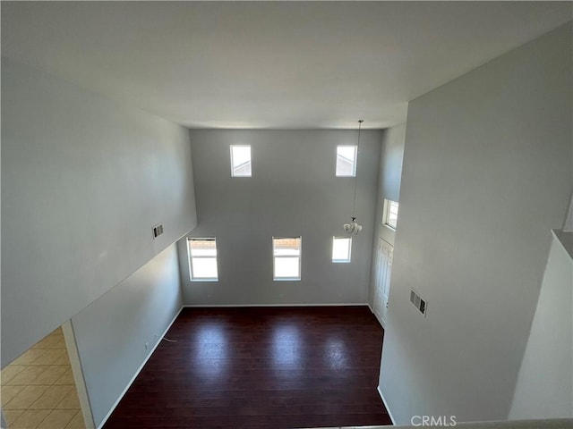 interior space with hardwood / wood-style flooring, a high ceiling, and an inviting chandelier