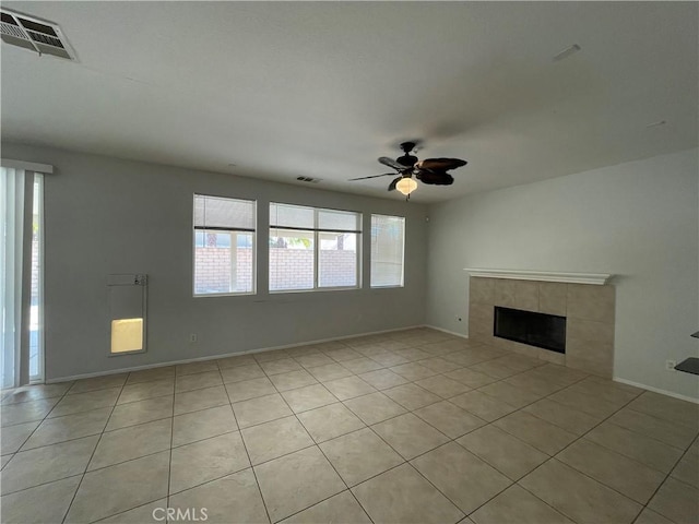 unfurnished living room featuring a tile fireplace, ceiling fan, and light tile patterned floors