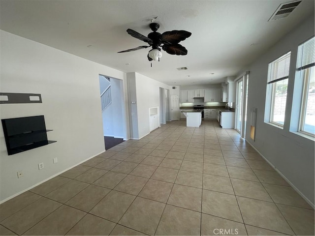 unfurnished living room with ceiling fan and light tile patterned flooring