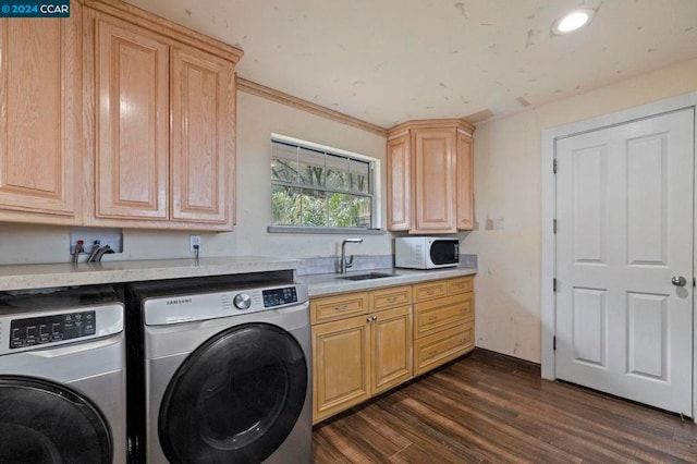 washroom featuring cabinets, dark hardwood / wood-style flooring, crown molding, sink, and washing machine and clothes dryer