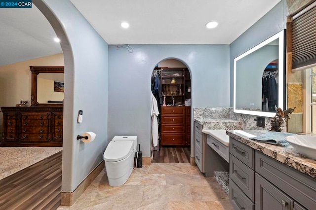 bathroom with hardwood / wood-style floors, vanity, tasteful backsplash, and toilet