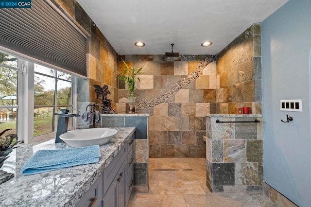 bathroom with vanity, a shower, and tile walls