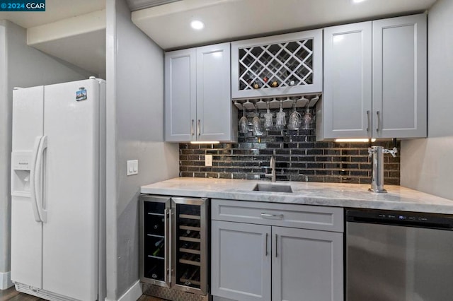 bar featuring white refrigerator with ice dispenser, tasteful backsplash, wine cooler, and stainless steel dishwasher