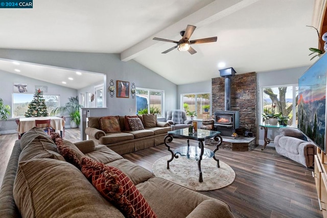 living room featuring vaulted ceiling with beams, a wood stove, ceiling fan, and dark wood-type flooring