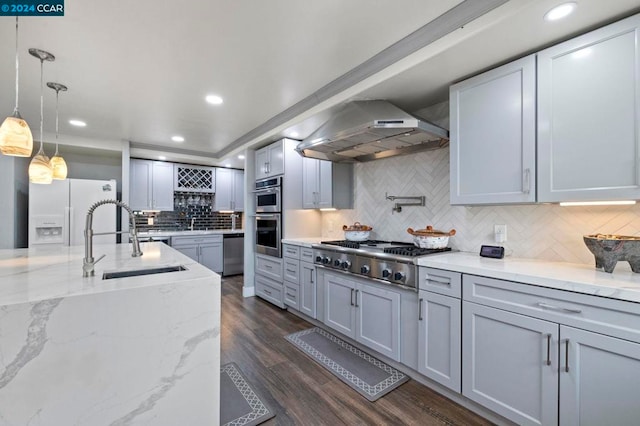 kitchen with gray cabinetry, sink, wall chimney exhaust hood, appliances with stainless steel finishes, and dark hardwood / wood-style flooring