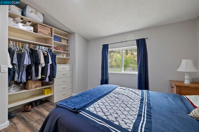 bedroom featuring hardwood / wood-style floors, a textured ceiling, and a closet