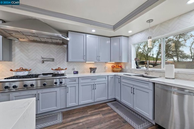 kitchen featuring wall chimney exhaust hood, hanging light fixtures, stainless steel appliances, dark hardwood / wood-style floors, and decorative backsplash