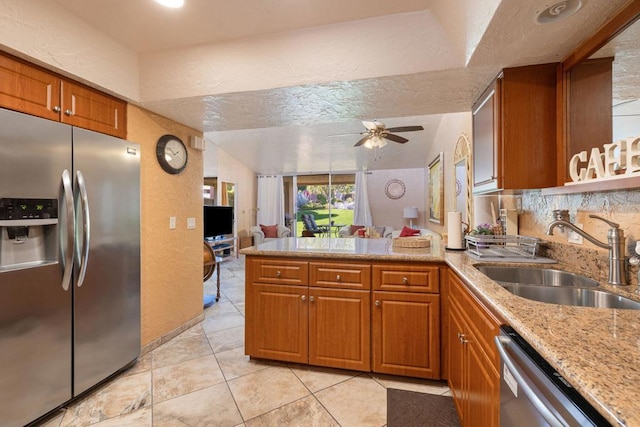 kitchen with light tile patterned floors, kitchen peninsula, ceiling fan, appliances with stainless steel finishes, and sink