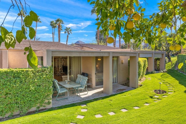 back of property featuring a lawn and a patio